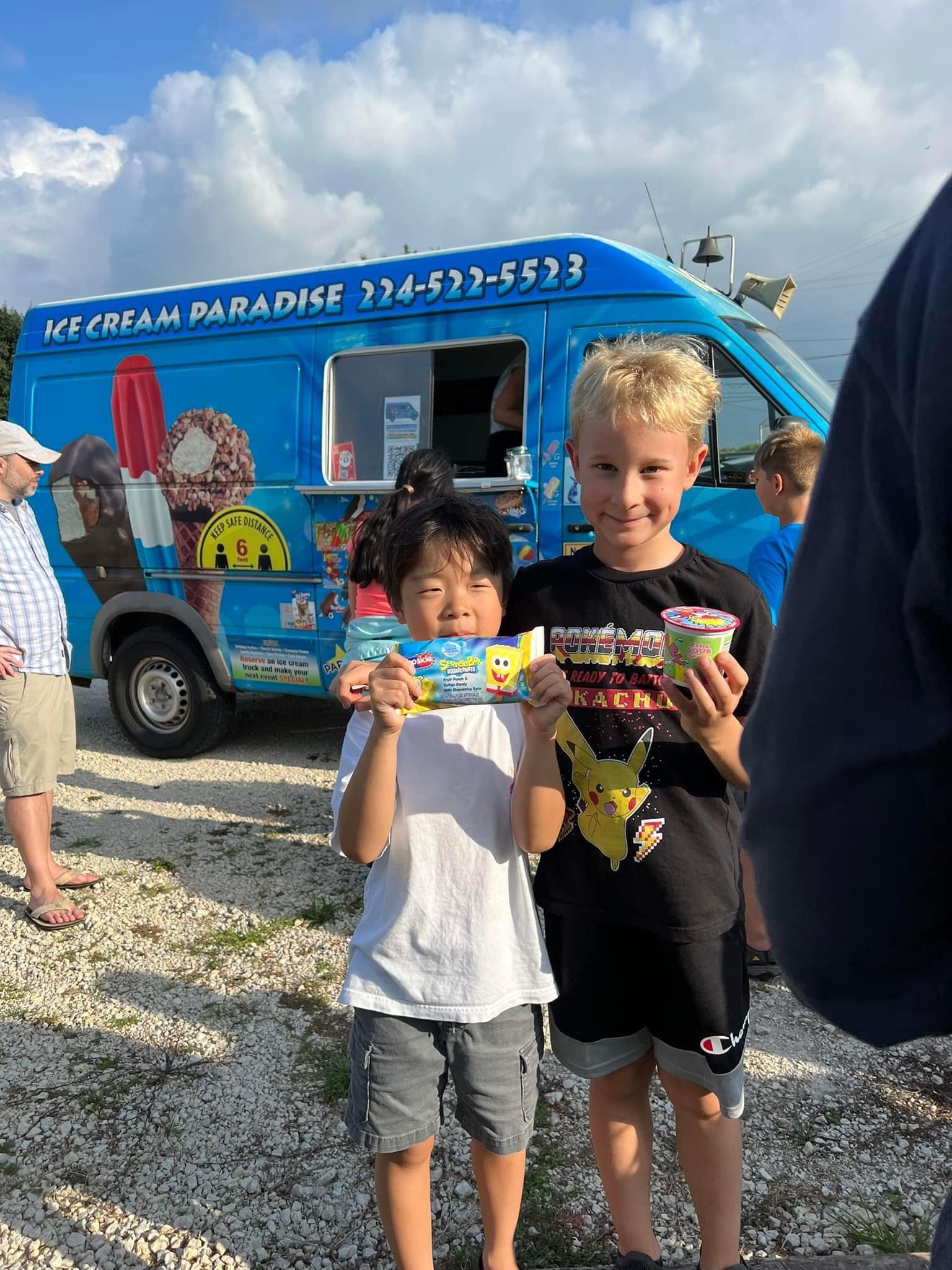 Two happy children holding ice cream treats and smiling