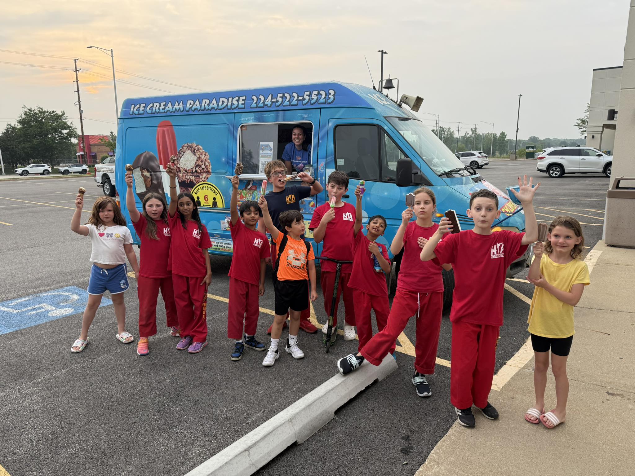 Large group of children and adults celebrating with ice cream treats